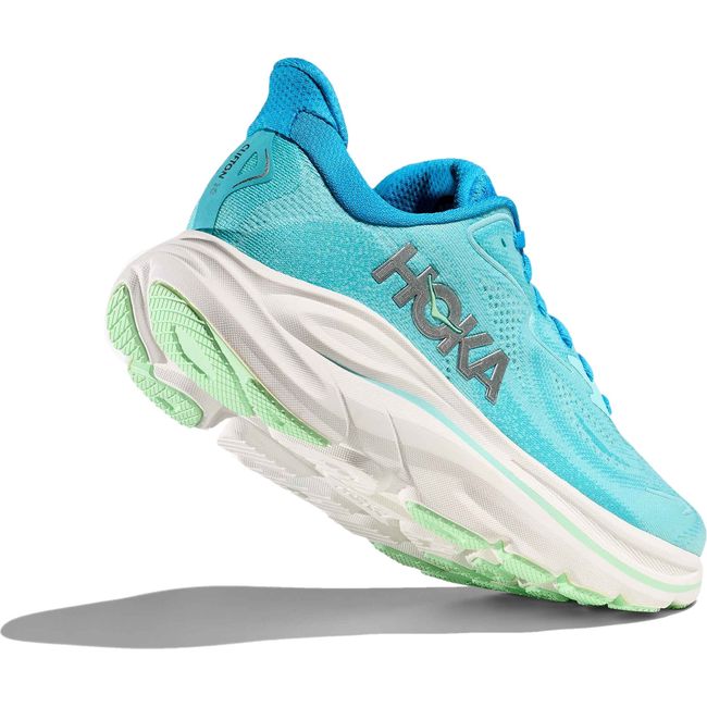 Heel angled up showing tread of Women's Hoka Clifton 10 Running Shoe in skyward blue