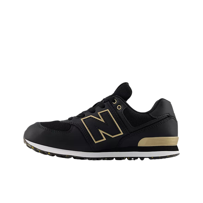 Medial side of New Balance Kids' 574 Lifestyle Shoe (Youth) in Black with gold