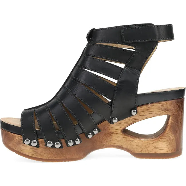 Medial side of Women's Dansko Adie Heel in Black Calf leather. A gladiator style heel