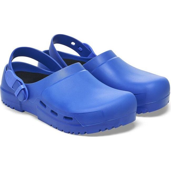 Angled view of a pair of blue Birkenstock Unisex Birki Air 2.0 Professional Clogs featuring a fluid-resistant design ideal for healthcare and utility. The clogs include side air vents for breathability, a polyurethane sole that is oil- and grease-resistant, a convertible backstrap, and adjustable detergent-friendly backstraps.