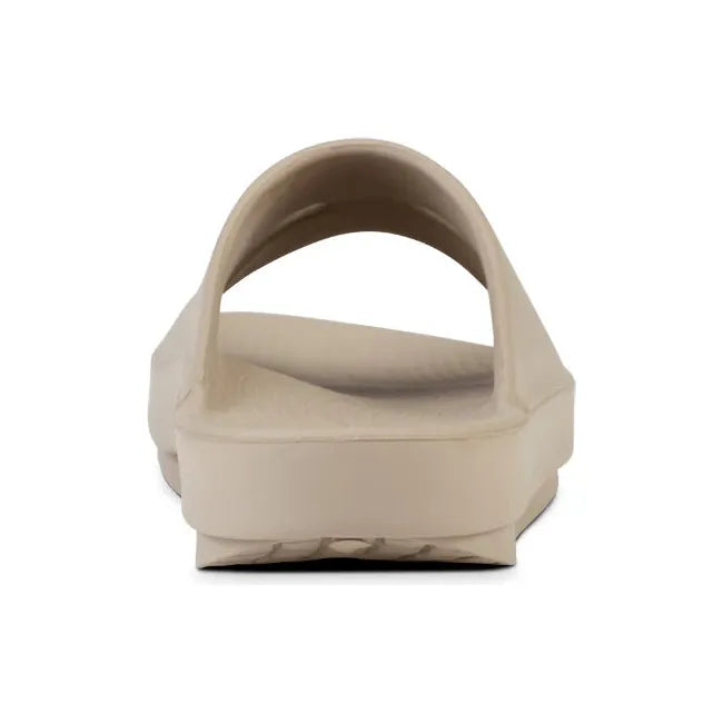 Heel of Unisex OOfos OOahh Slide Sandal in Nomad Beige