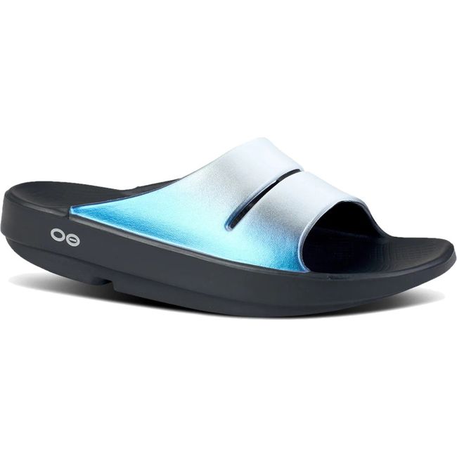 Front angled view of Women's OOfos OOahh Luxe Slide Sandal in Frost silver and blue