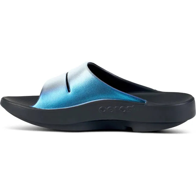 Medial side of Women's OOfos OOahh Luxe Slide Sandal in Frost silver and blue