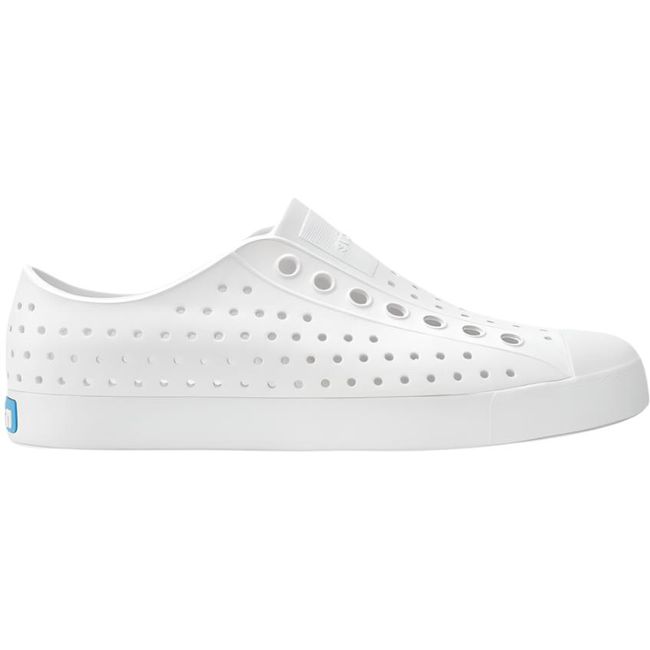 Lateral side view of the Native Big Kids' Jefferson Shoe in shell white, featuring a slip-on design, lightweight and hand-washable Sugarlite™ material, a perforated upper similar to Crocs, and a white toe cap for added design.