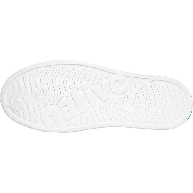 Sole view of the Native Big Kids' Jefferson Shoe in shell white, featuring the word 'native' embossed in the tread.