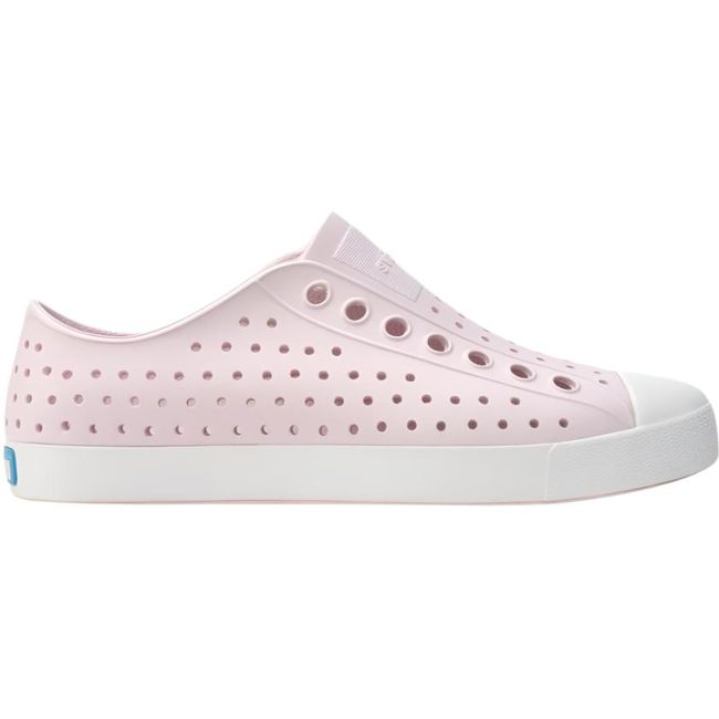 Lateral side view of the Native Big 
Kids' Jefferson Shoe in pink, featuring a slip-on design, lightweight and hand-washable Sugarlite™ material, a perforated upper similar to Crocs, and a white toe cap for added design.