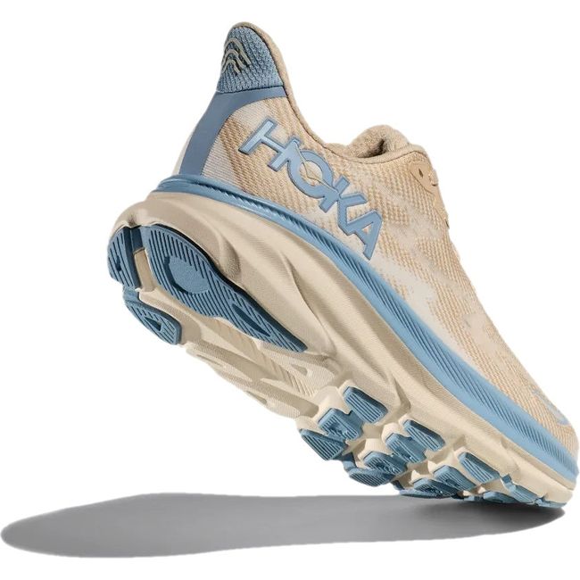 Heel up view of Womens Hoka Clifton 9 Running Shoe in Oak Alabaster tan and blue. Shows blue tread