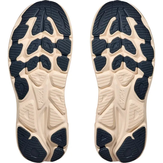 Outsole pair view of Hoka Clifton 10 showing navy abrasion rubber traction pattern and cream midsole