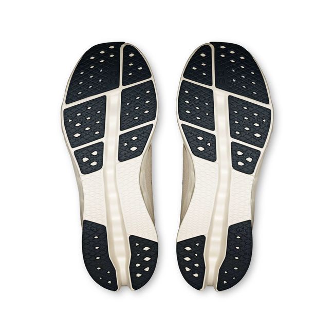 Soles of On Running Women's Cloudsurfer 2 Running Shoe in Pearl Ivory Beige with black tread