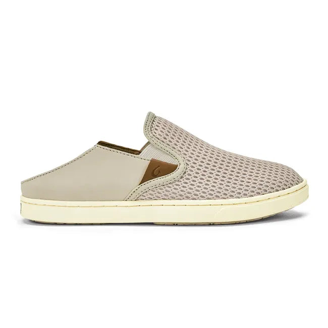 Heel down lateral side of slip on Women's Olukai Pehuea Shoe in beige mesh with off white sole.