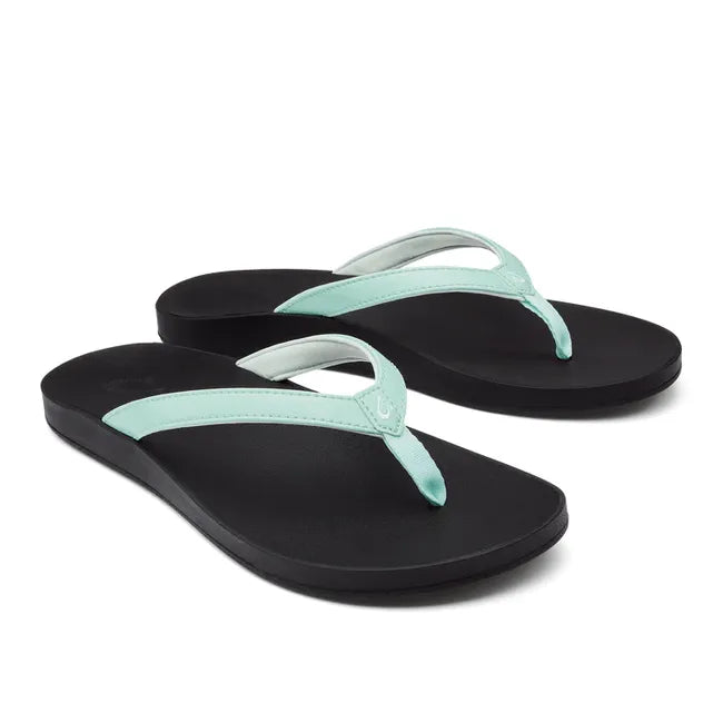 Pair of Women's Olukai Puawe Flip Flop with a sea glass green colored upper and black sole.