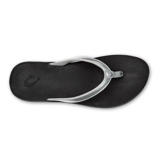 Top down view of Women's Olukai Puawe Flip Flop with a silver upper and black sole.