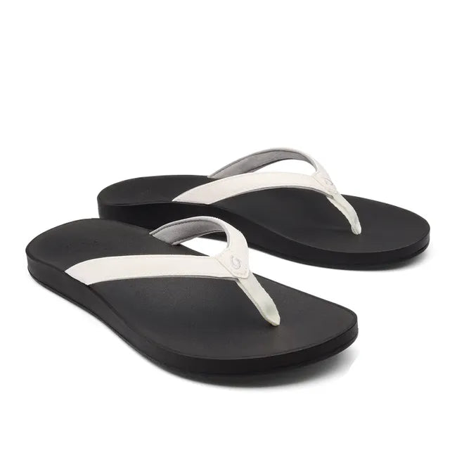 Pair of Women's Olukai Puawe Flip Flop with white upper and black sole.