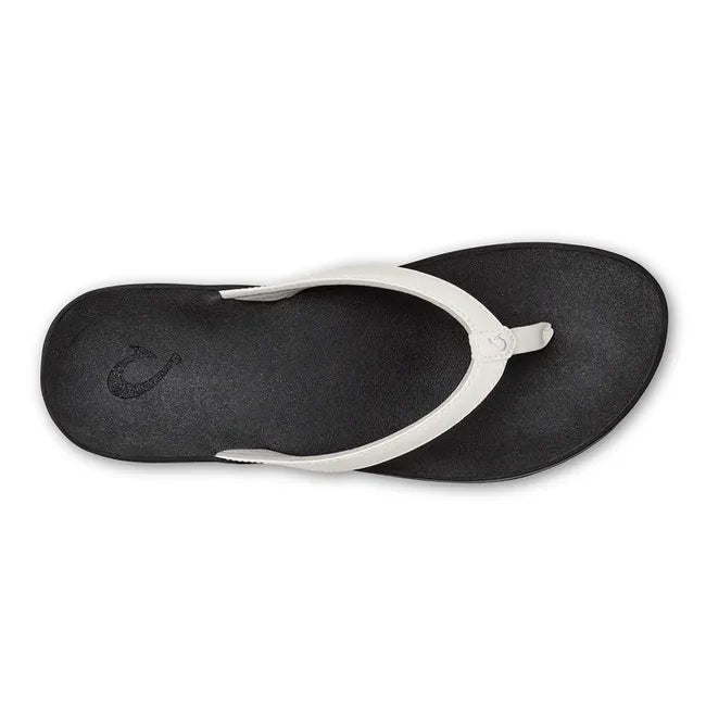 Top down view of Women's Olukai Puawe Flip Flop with white upper and black sole.