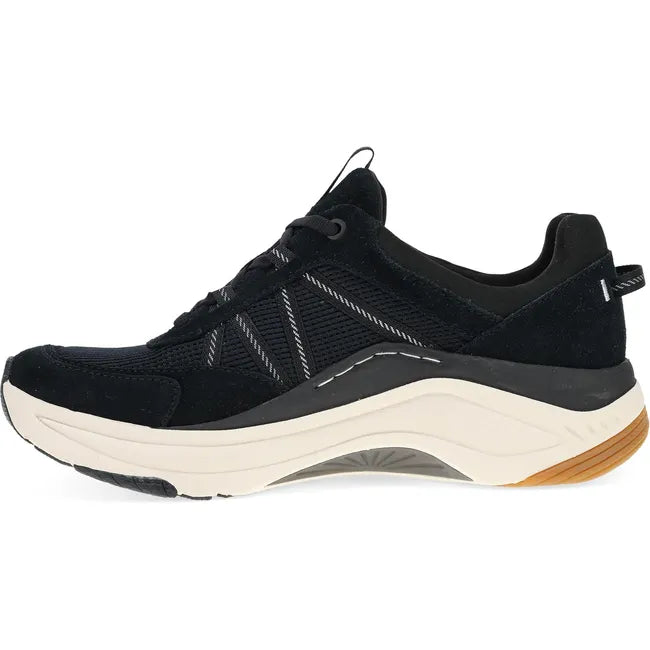 Medial side of Women's Dansko Poppy Sneaker in black suede with white cushioned sole