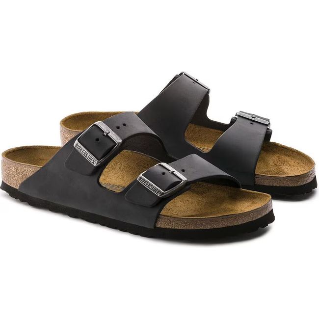 A pair of black Birkenstock Arizona sandals with cork footbeds and two adjustable straps each.