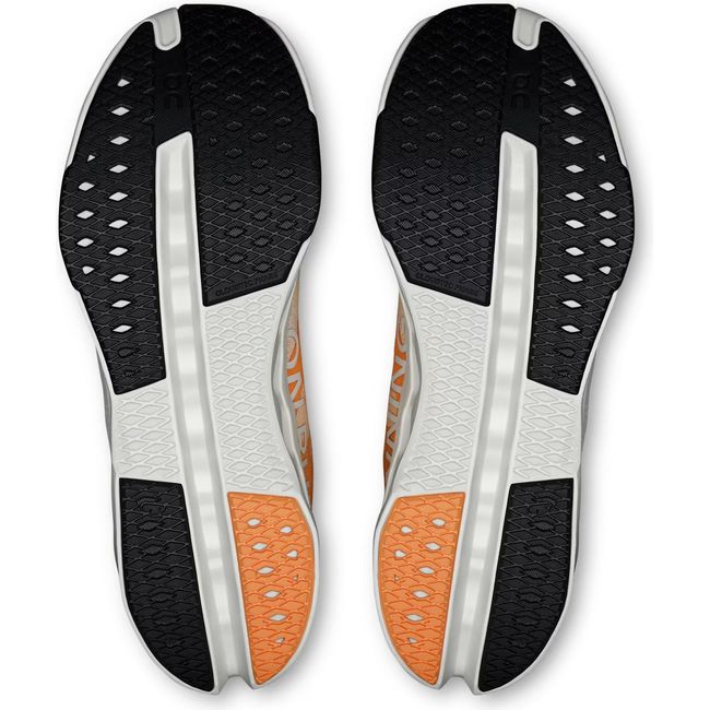 Soles of Men's On Running Cloudsurfer Next Running Shoes in Tangerine and Ivory with black tread