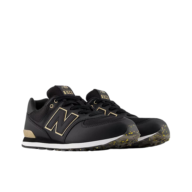 Angled Pair of New Balance Kids' 574 Lifestyle Shoe (Toddler/Little Kid) in Black with Gold
