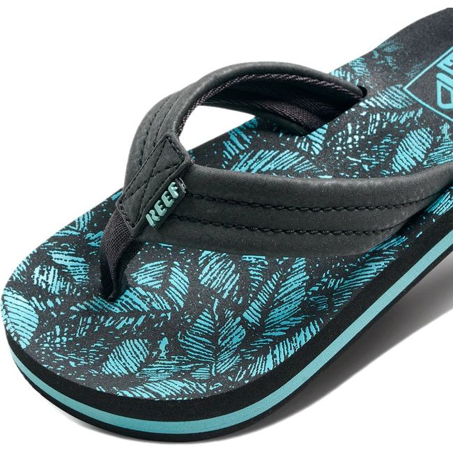 Close up of front of Kids' Reef Ahi Flip Flop in Aquifer Palm black and blue