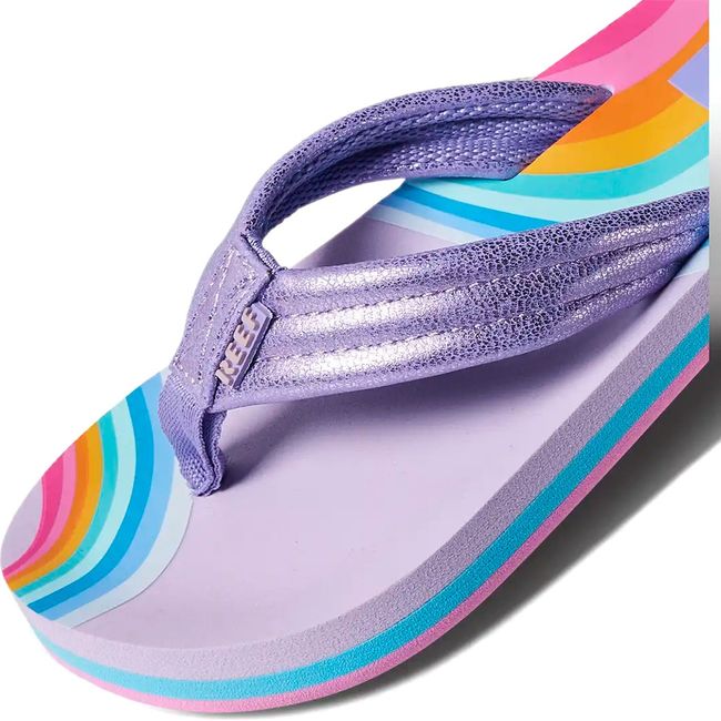 Close up view of the strap of Kids' Reef Ahi Flip Flop in Candyland purple with rainbow patterns