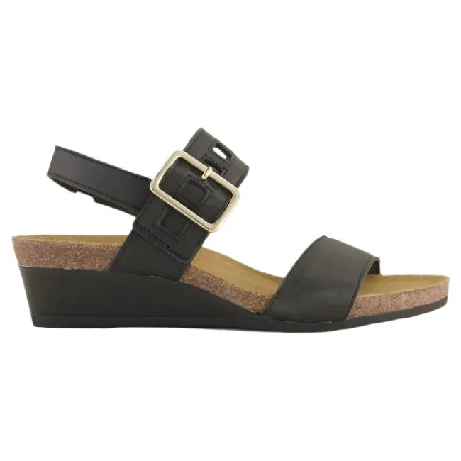 Lateral side view of Naot Women's Dynasty Wedge Sandal in black leather, featuring a hook and loop closure for adjustability and a comfortable brown anatomic cork and latex footbed.