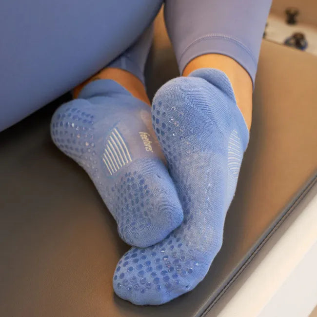 Women's Feetures Elite Grip Max Cushion Tab Sock in Flex Blue, shown worn on feet with sole grips