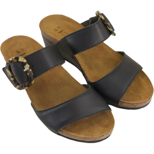 Overhead view of a pair of Naot Women's Kingdom Wedge Sandal in black, featuring an oversized buckle, a 1.75-inch polyurethane wedge heel, and a suede-wrapped anatomic cork and latex footbed.