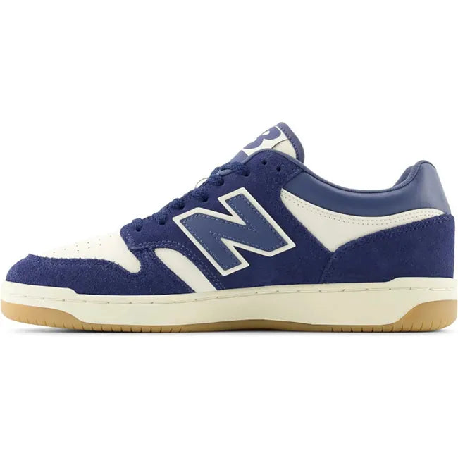 Medial side of Unisex New Balance 480 sneakers in navy blue and off-white with a gum sole.