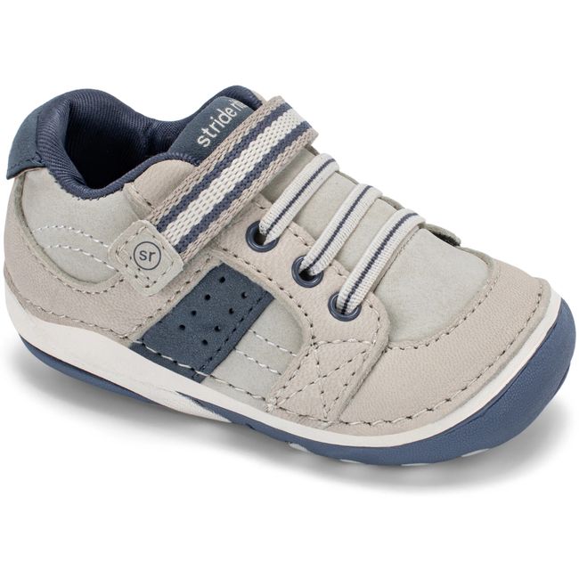 Stride Rite Artie sneaker in stone grey leather with deep navy accents, angled view