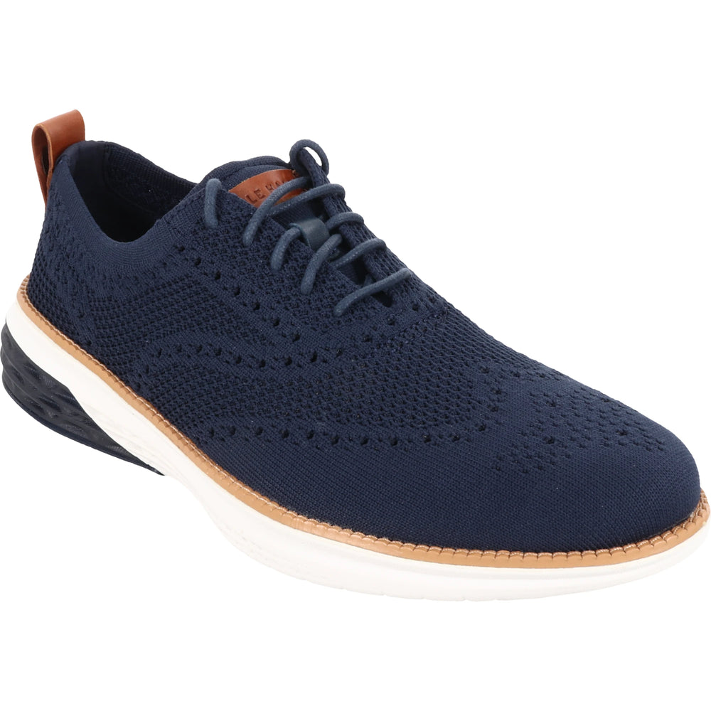 Front angled view of Cole Haan Men's Grand Hurrion Stitchlite Wingtip Oxford in Navy Blazer-British Tan-Ivory