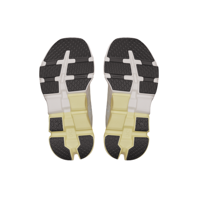 Soles of On Cloud Cloudflyer 5 sneakers. Half white, half yellow midsole cushioning, black tread