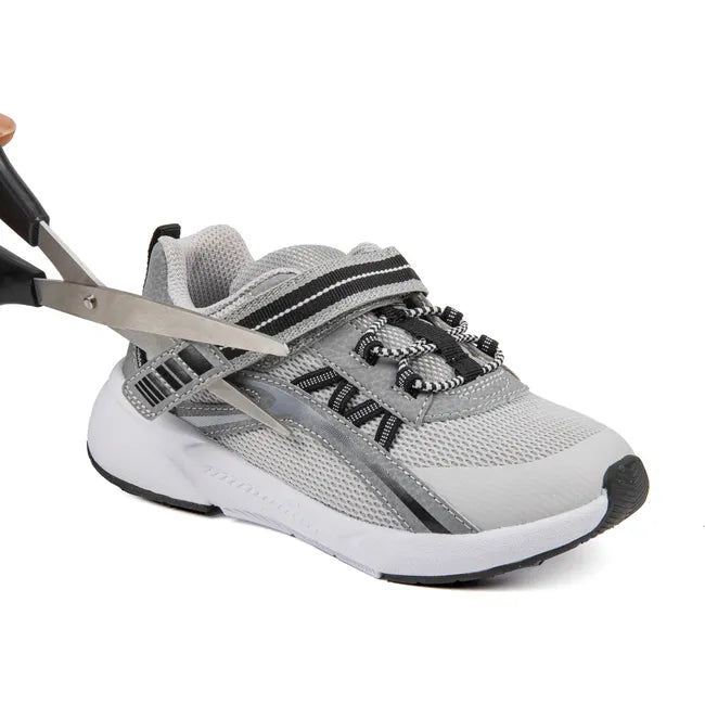 Scissors cutting adjustable velcro of Kids' Stride Rite Journey 3.0 Adaptable Sneaker in Grey