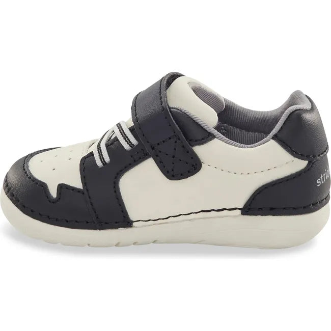 Medial side of Kids Stride Rite Waverly Sneaker in black and white with velcro strap