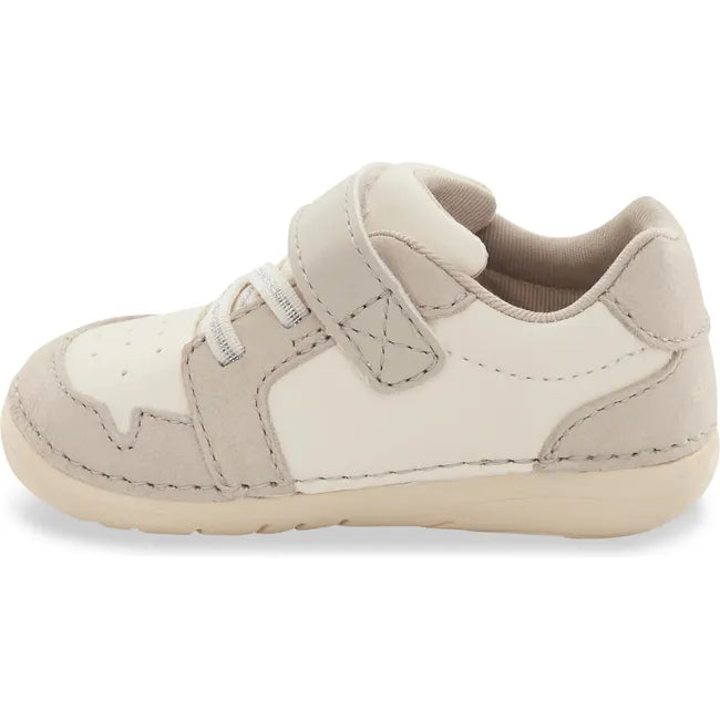 Medial side of Kids Stride Rite Waverly Sneaker in ecru beige and white with velcro strap