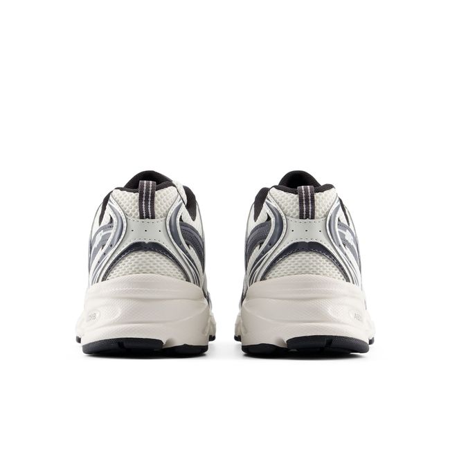 Rear heel view of the New Balance 530 pair in off-white and charcoal