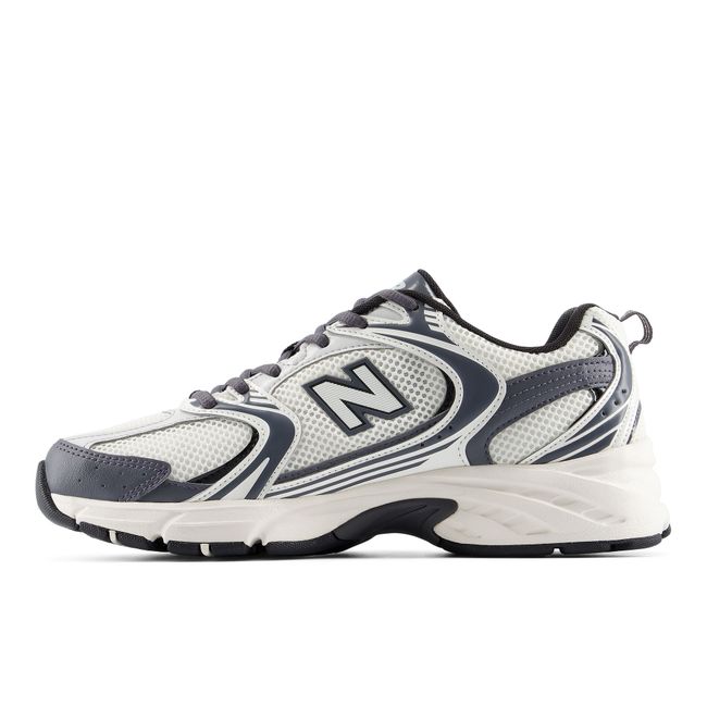 Medial profile of the New Balance 530 in off-white with charcoal overlays