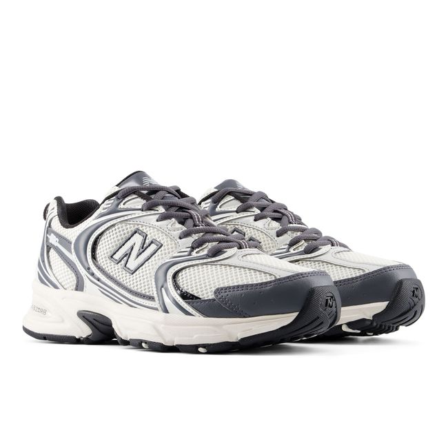 Pair of New Balance 530 retro sneakers in off-white and charcoal grey