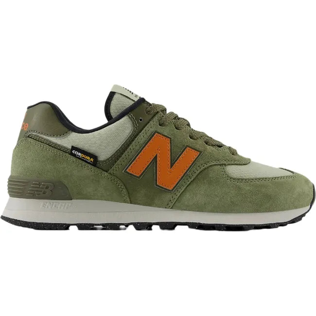 Lateral side of Unisex New Balance 574 sneakers in olive green suede with orange accents.