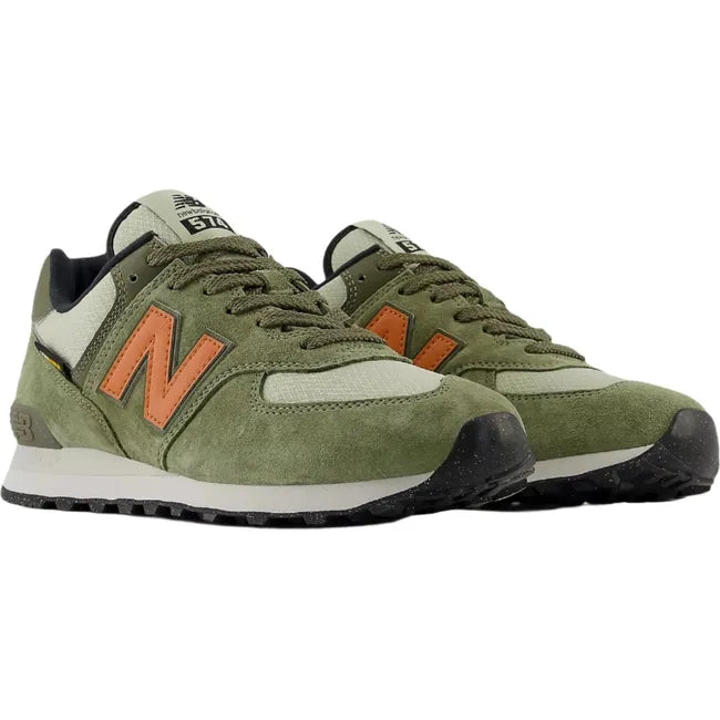Pair of Unisex New Balance 574 sneakers in olive green suede with orange accents.