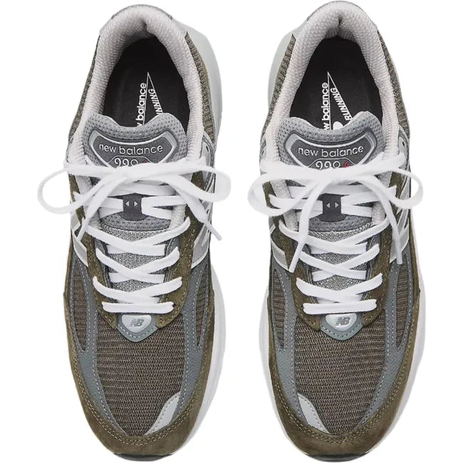 Lateral side of New Balance 990v6 sneakers in suede olive green and gray with a chunky sole.