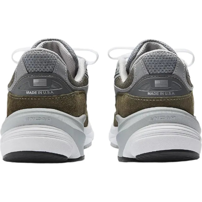 Heels of New Balance 990v6 sneakers in suede olive green and gray with a chunky sole.