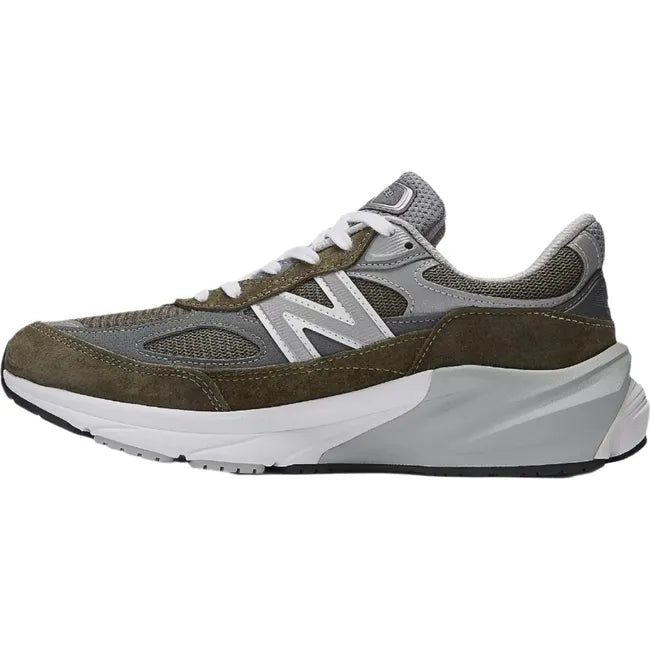 Medial side of New Balance 990v6 sneakers in suede olive green and gray with a chunky sole.