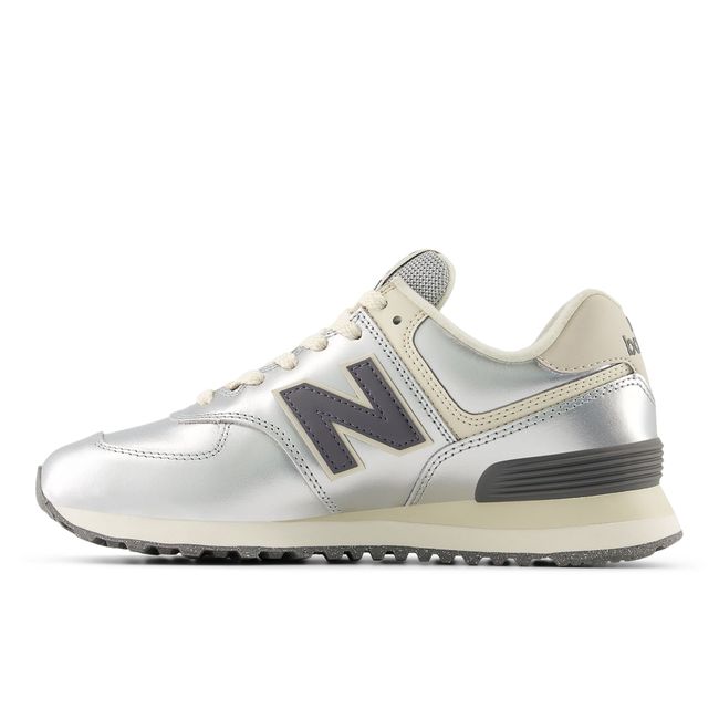 Medial profile of the New Balance 574 in metallic silver with cream panels