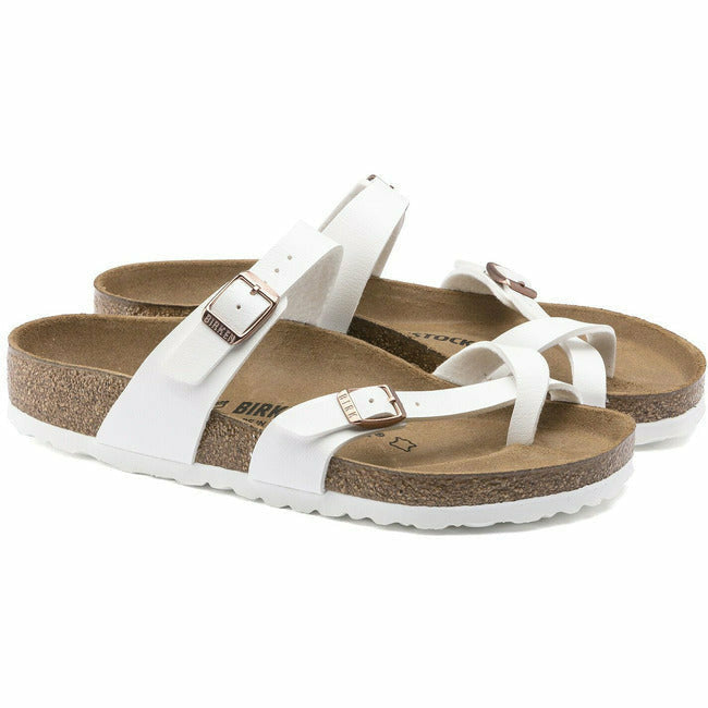 A pair of a white leather Birkenstock Mayari sandals with copper adjustable buckles.